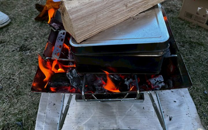 焚き火台の上で蒸し焼きになる牡蠣の容器