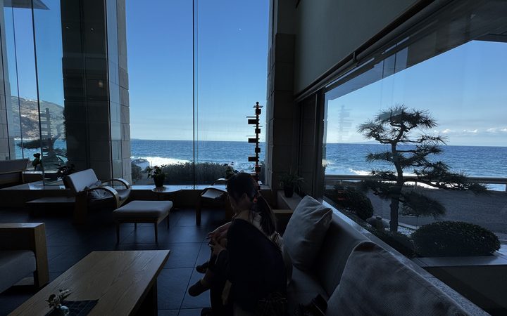 宿のロビーから海と松を眺める