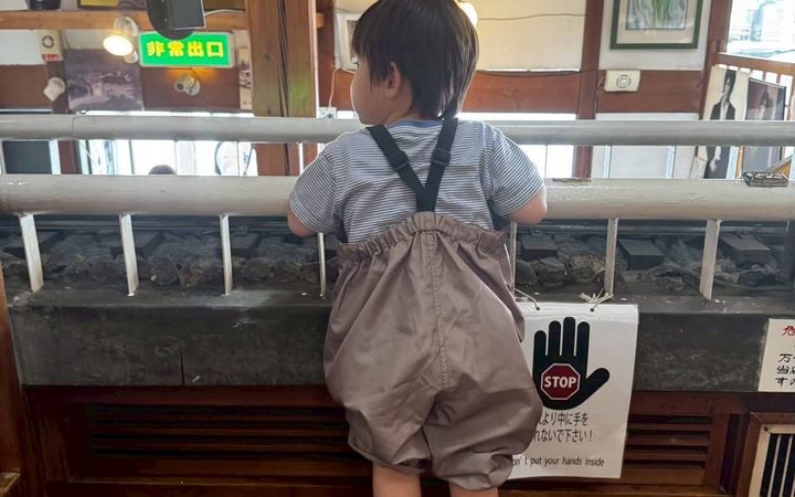 店内のレールを覗き込む子供