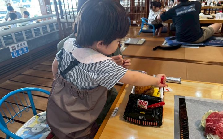D-51を模したお弁当容器でご飯を食べる子供